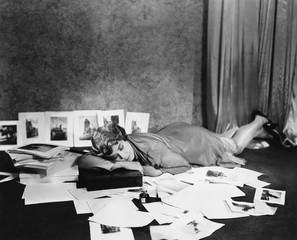 Woman asleep on floor surrounded by illustrations 