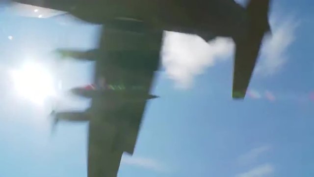 A C-130 cargo plane lands on a dirt runway.