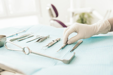 Detail of hand holding dental tools in dental clinic.
