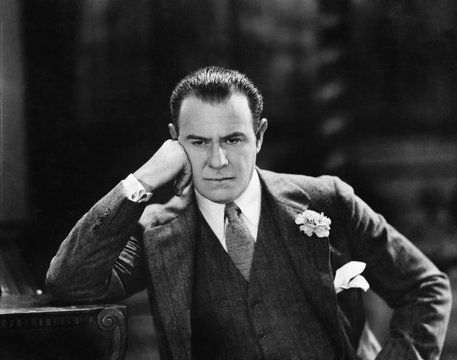 Man with head leaning against his hand thinking 
