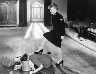Female officer punishing her maid by forcing her head into a bucket 