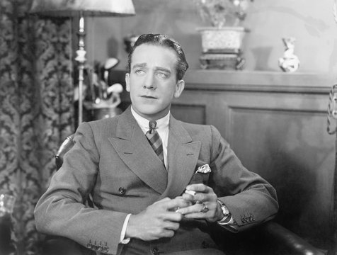 Man sitting and holding a cigarette 