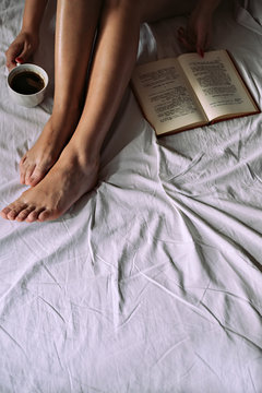 Girl reading book and drinking coffee