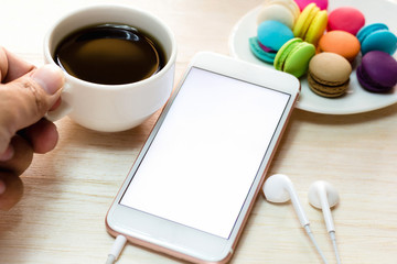 Office workspace with keyboard notepad coffee of cup and smartphone on wood table.