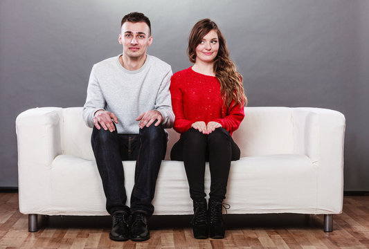 Shy woman and man sitting on sofa. First date.