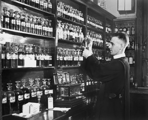 Man in a pharmacy mixing medicine 