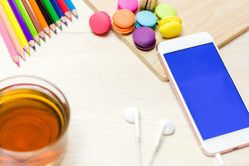 Office workspace with keyboard notepad coffee of cup and smartphone on wood table.