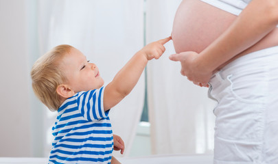 Boy looking at mother pregnant tummy