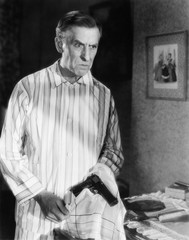 Man holding a handgun in a handkerchief looking distraught 
