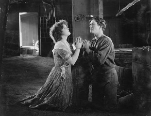 Couple praying together in barn 