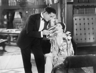 Man feeding food on a fork to a woman 