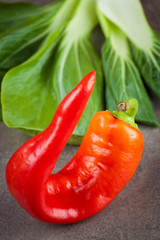 Sweet red chilli and bok choi leafs. Healthy raw ingredients. Shallow depth of field.