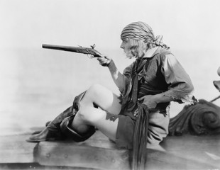 Profile of a young woman holding a flintlock pistil in a pirates outfit 