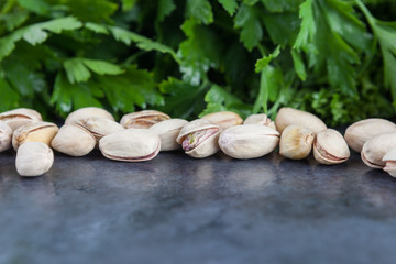 Pistachios and parsley on grunge background. Shallow depth of field.