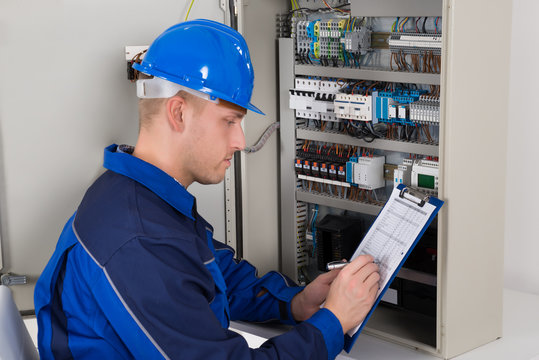 Young Male Technician Examining Fusebox