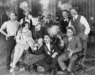 Group of people sitting in a living room smoking 