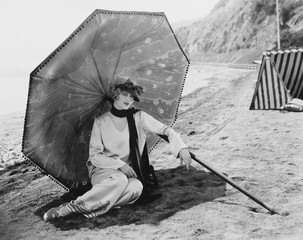 Woman with umbrella at beach 