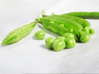 Green Peas and pea fruit the legume on white.