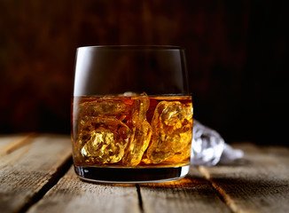whiskey with ice on a wooden background
