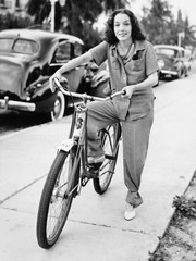 Portrait of a young woman holding a bicycle and smiling 
