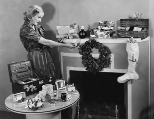 Woman with Christmas presents on mantle 