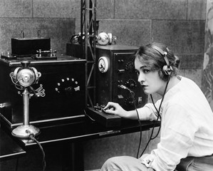 Woman sending Morse code using telegraph 