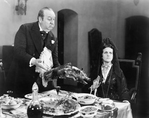 Woman looking away from a roasted piglet 