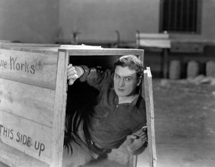 Man hiding in wooden crate 