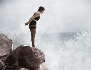 Kobieta pływak na skale powyżej awarii surfowania - 104453914