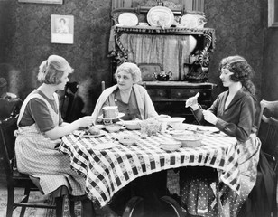 Three women sitting at the dining table talking 