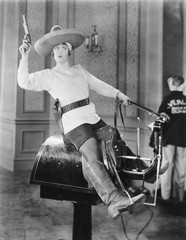 Woman playing cowgirl on mechanical horse 