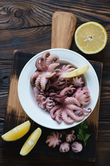 Above view of a glass plate with pickled baby octopuses