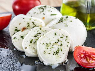 Mozzarella and tomatoes. Dark grey background.