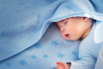 three month old baby sleeping on blue blanket