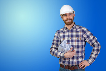 Young male engineer with helmet holding blueprints