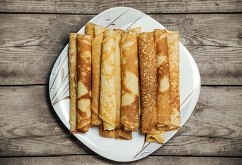 Roasted rolled pancakes on a square plate.