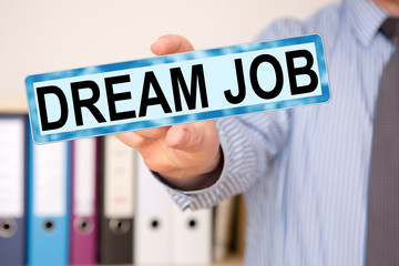 Businessman holding sign with inscription, DREAM JOB