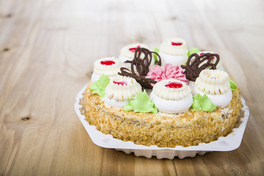 Cake with cream on a wooden table