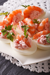Delicious eggs stuffed with seafood close up on the table. vertical
