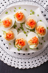 Eggs stuffed with salmon, cheese and cucumber closeup. vertical top view
