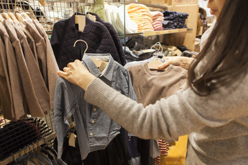 Women are choosing the clothes of her daughter in clothes shop
