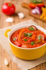 Delicious letcho with fresh vegetables, served in a yellow pot w