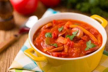 Delicious letcho with fresh vegetables, served in a yellow pot w
