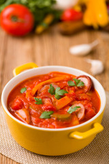 Delicious letcho with fresh vegetables, served in a yellow pot w
