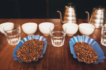 Roasted coffee beans with cups ready for a tasting