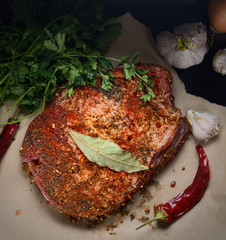 raw piece of pork, onion, pepper, garlic, parsley