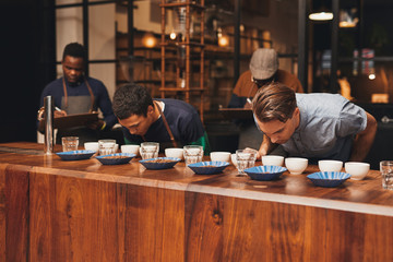 Barista training in a modern roastery with managers taking notes