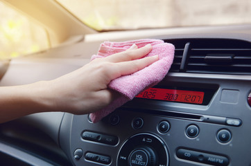 Hand with cloth polishing car.