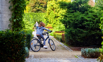 Father and daughter enjoy riding on bikes in park