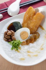 Asian porridge with salted egg, peanut, deep-fried dough stick 